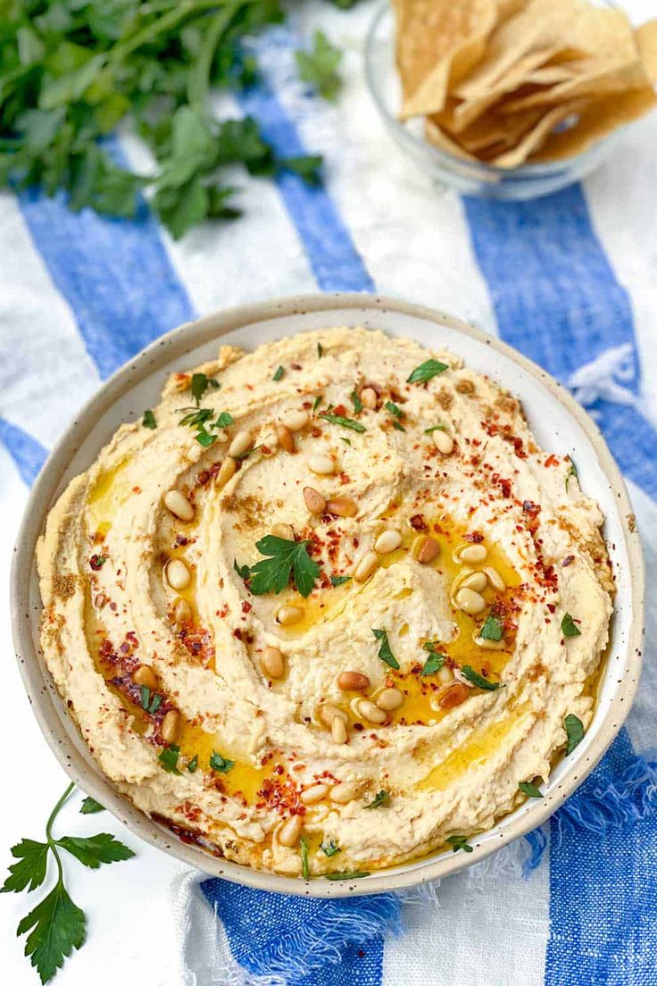 a bowl filled with hummus and garnished with cilantro