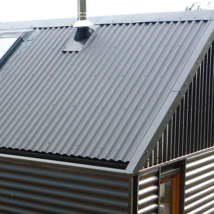 a small metal building with a bird perched on it's roof