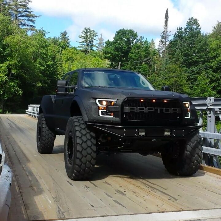 a large black truck driving down a road