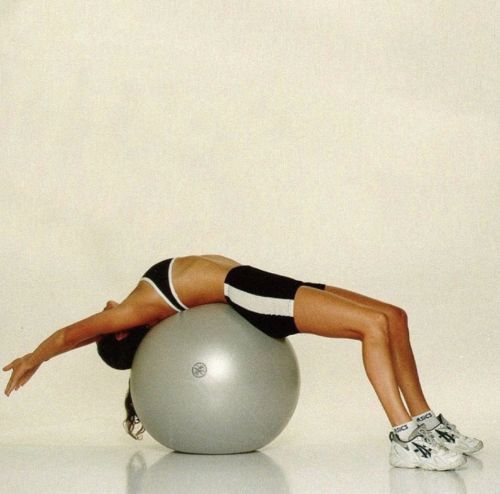 a woman is doing exercises on an exercise ball with her arms and legs stretched out