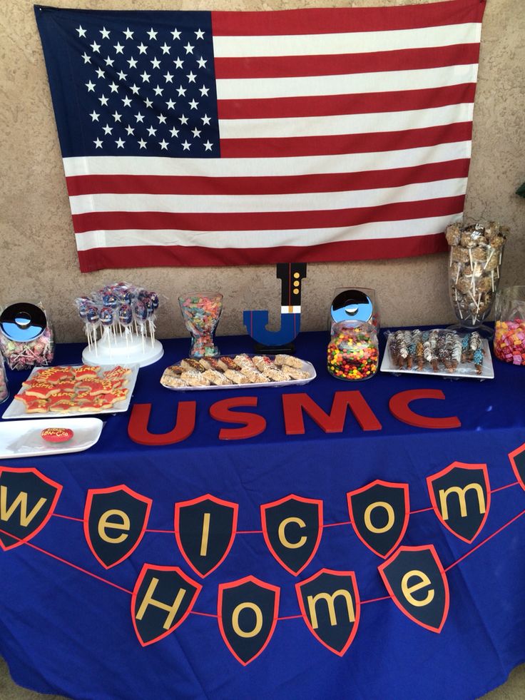 an american flag and welcome home sign are displayed on a table with snacks for the guests