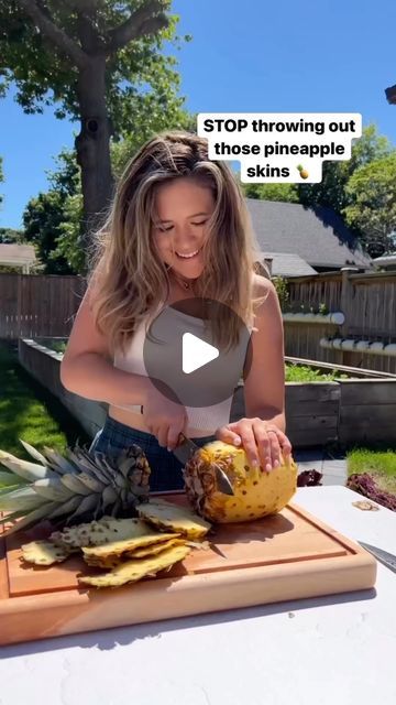 a woman cutting up pineapples on top of a table