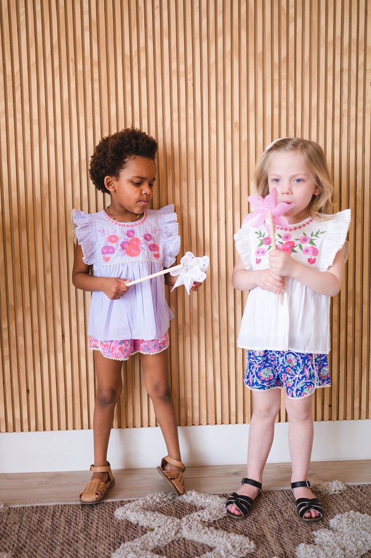 Introducing our newest blouse and short set! This adorable two-piece features a beautiful floral embroidered cotton blouse, paired with colorful block print shorts with little lace trim. She'll look absolutely precious in this ensemble - perfect for a day of play! Embroidered Short Sleeve Spring Sets, Sleeveless Multicolor Embroidered Summer Sets, Blue Embroidered Summer Sets, Embroidered Short Sleeve Summer Sets, Semi-stitched Light Blue Embroidered Sets, Cotton Blouses, Printed Shorts, Short Sets, Block Print