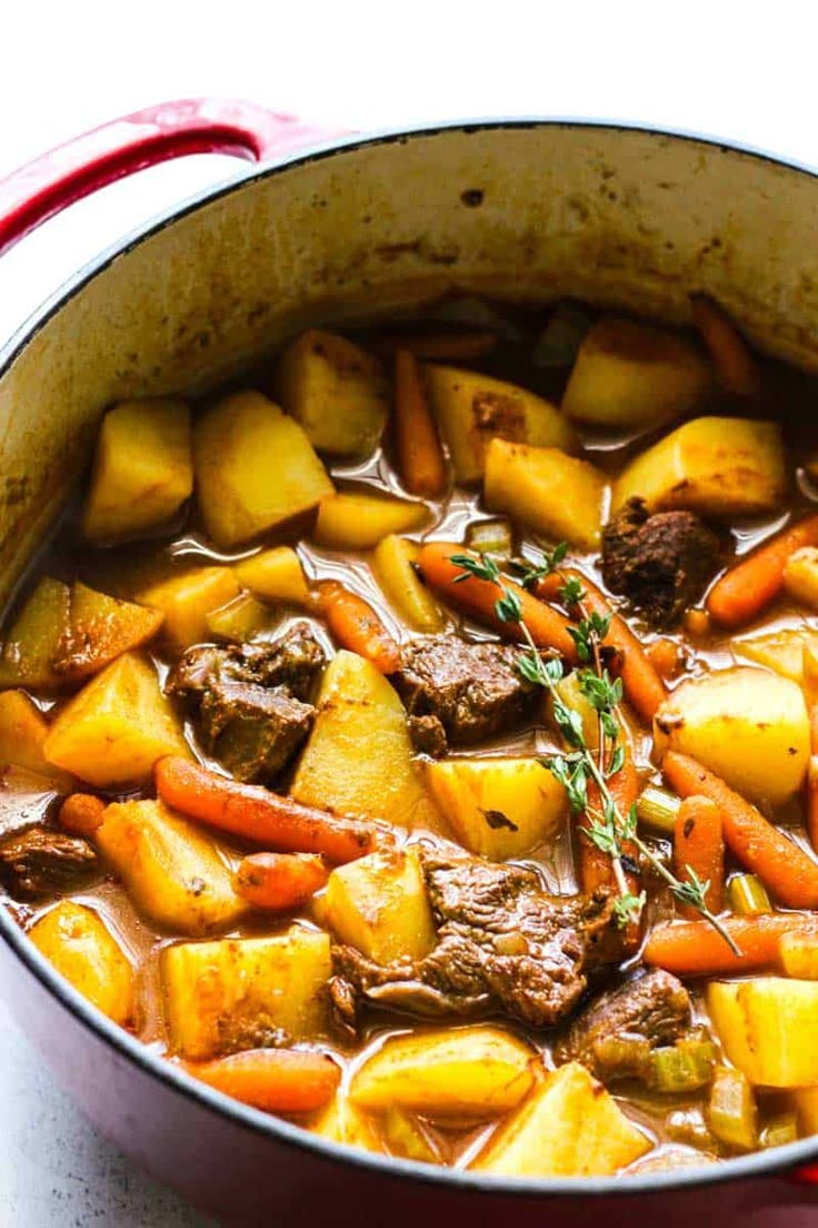 a pot filled with stew and potatoes on top of a table