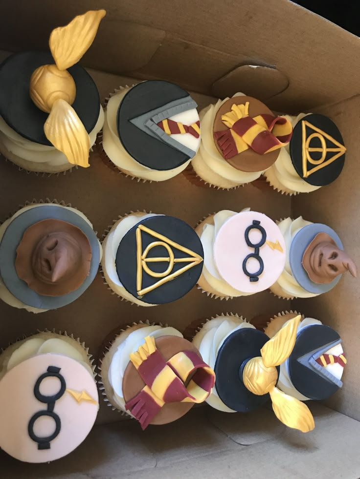 cupcakes decorated with harry potter symbols in a box