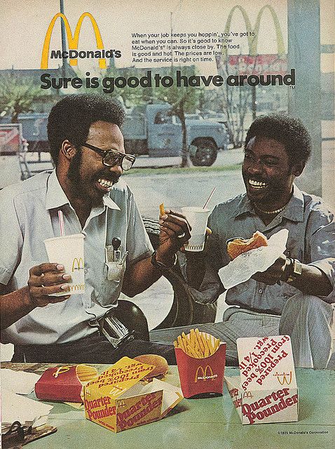 two men sitting at a table eating food