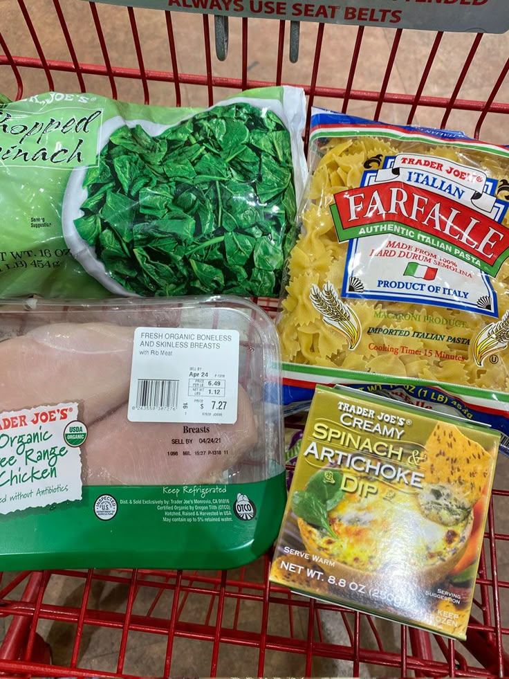 three packages of frozen food sitting on top of a shopping cart