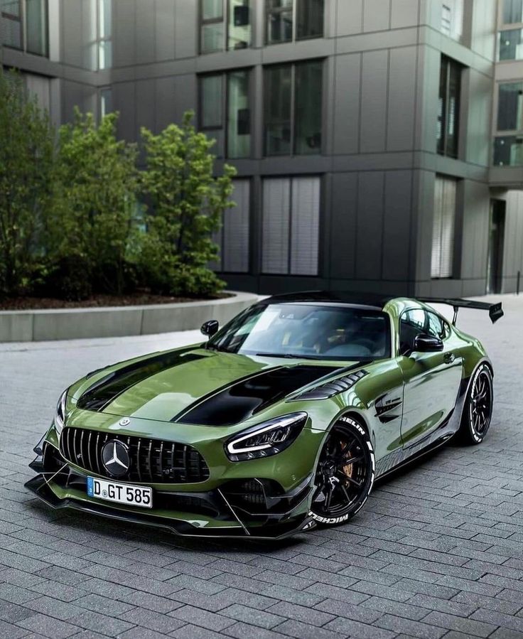 a green mercedes sports car parked in front of a building