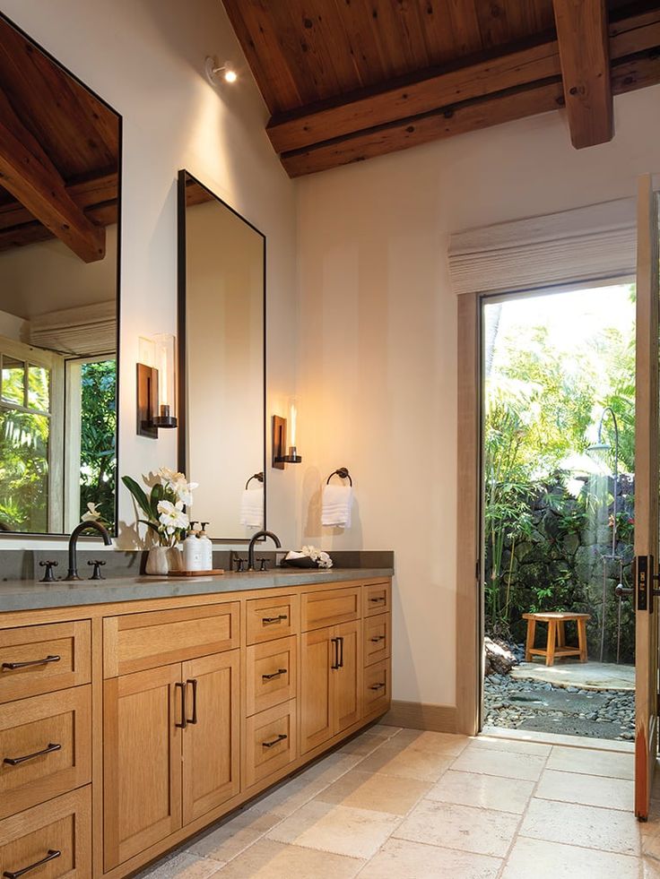 a bathroom with double sinks and large mirrors on the wall next to sliding glass doors