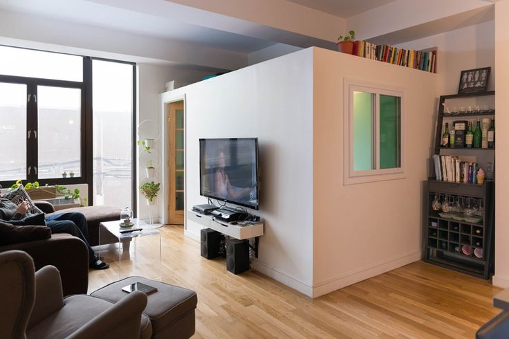 a living room filled with furniture and a flat screen tv on top of a wooden floor