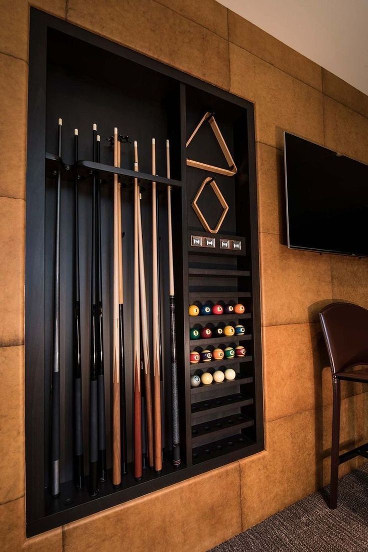 a wall mounted billiards rack with pool cues and cues