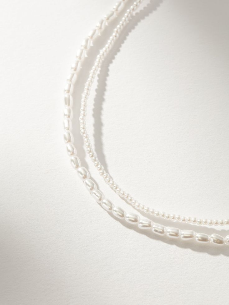 Add some timeless, classic layers to your look with our Layered Pearl Necklace. With one strand of mini pearls and another strand of larger pearls, this layered necklace is all you need. For a full look, pair this double pearl necklace with your other favorite pearl jewelry styles. Layering Beaded Pearl Necklaces, Classic Pearl Pendant Necklace For Layering, Classic Layering Pearl Necklace, White Pearl Beaded Necklaces For Layering, Classic Pearl Necklace For Layering, Double Strand Pearl Chain Beaded Necklaces For Layering, Classic White Necklace For Layering, Classic Multi-strand Pearl Necklace With Charm, White Delicate Pearl Necklace For Layering