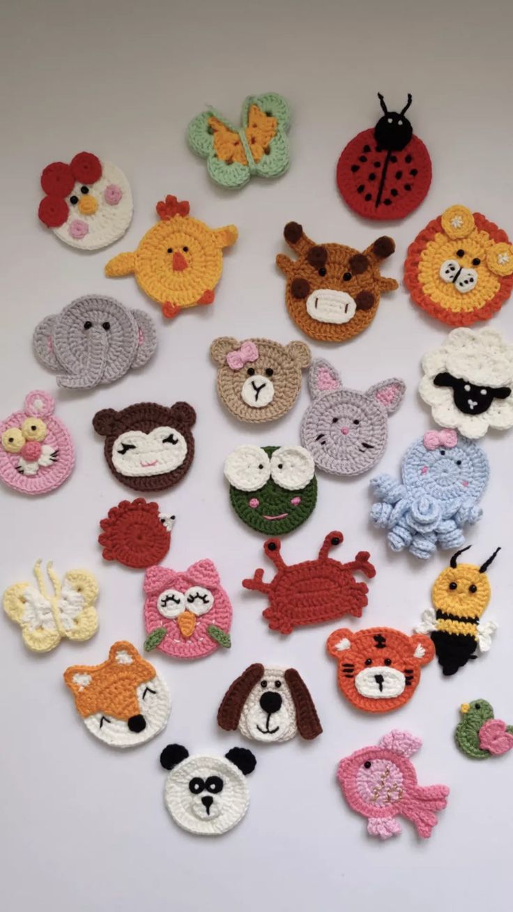 crocheted animals and ladybugs are arranged on a white surface