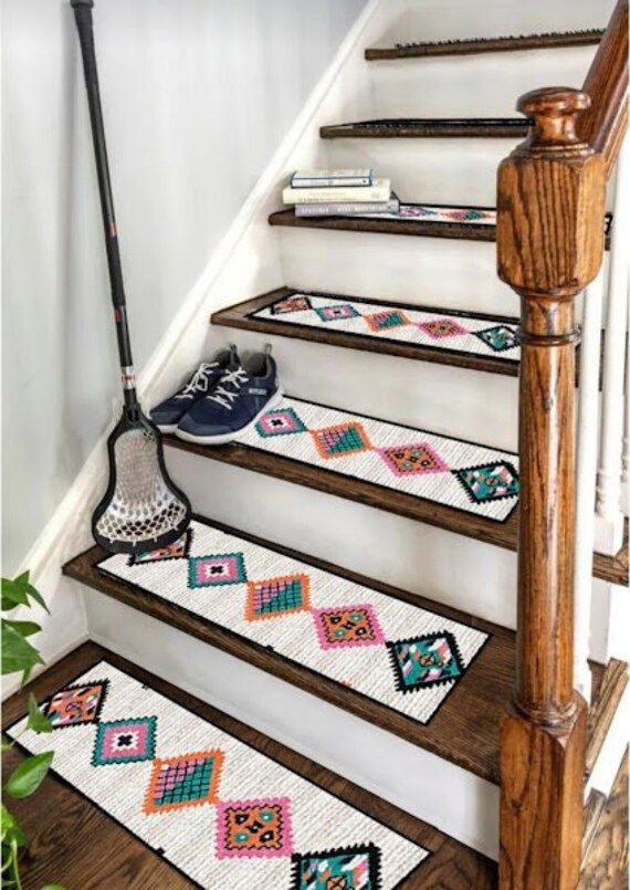 the stair treads are decorated with patchwork rugs and an iron mop