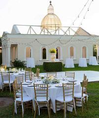 an outdoor venue with tables and chairs set up for a formal dinner or party in front of a gazebo