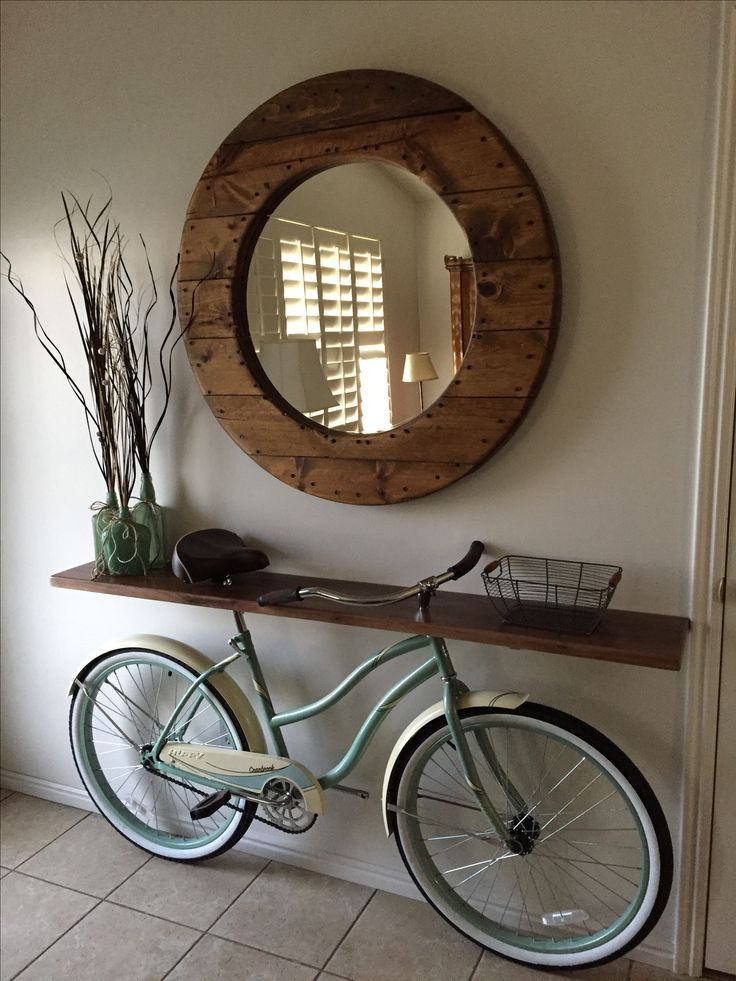 a bicycle is parked in front of a wall with a round mirror on the wall