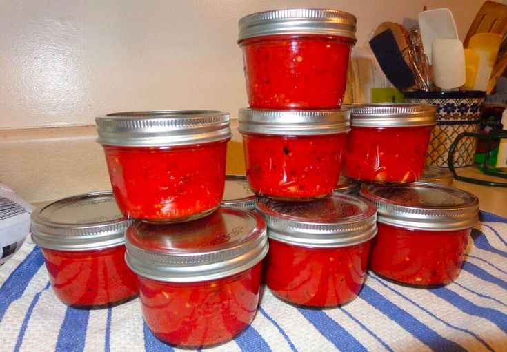 six jars of tomato sauce sitting on top of a blue and white towel