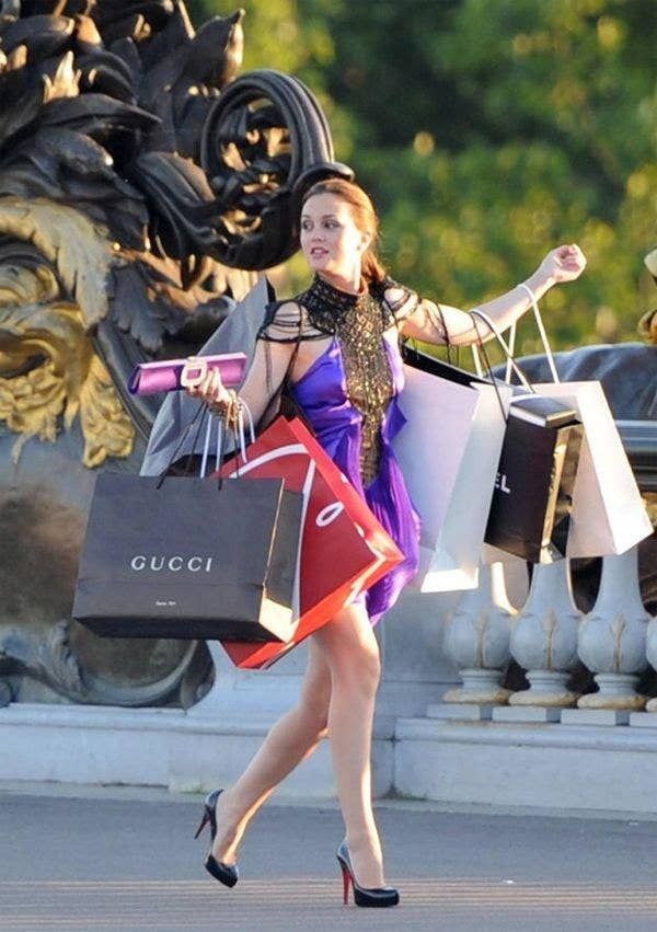 a woman carrying shopping bags while walking down the street