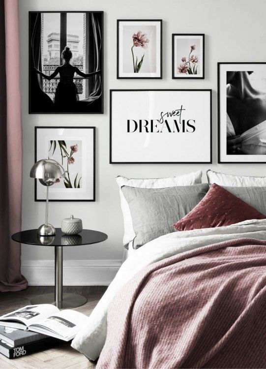 a bedroom with pictures on the wall above it and a bed covered in pink sheets