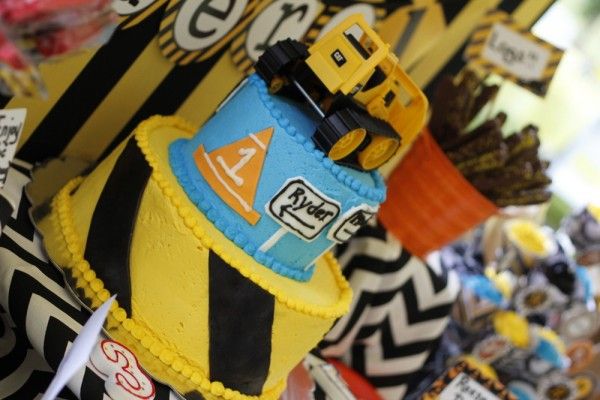 there is a yellow and black cake with cars on it