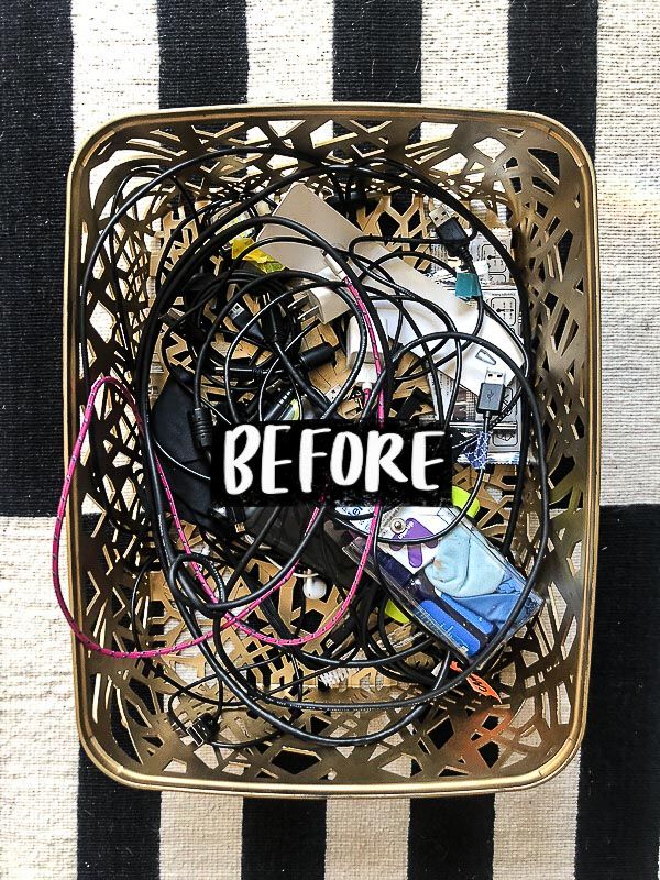 a metal basket filled with electronics on top of a black and white striped table cloth