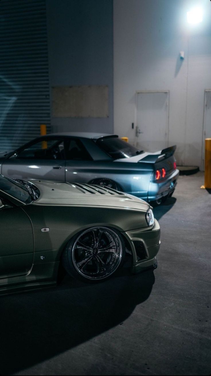 two cars parked next to each other in a garage