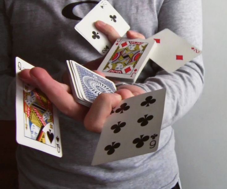 a person holding four playing cards in their hands and two on the other hand,