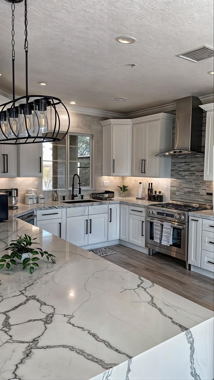 a large kitchen with marble counter tops and white cabinets, an island in the middle