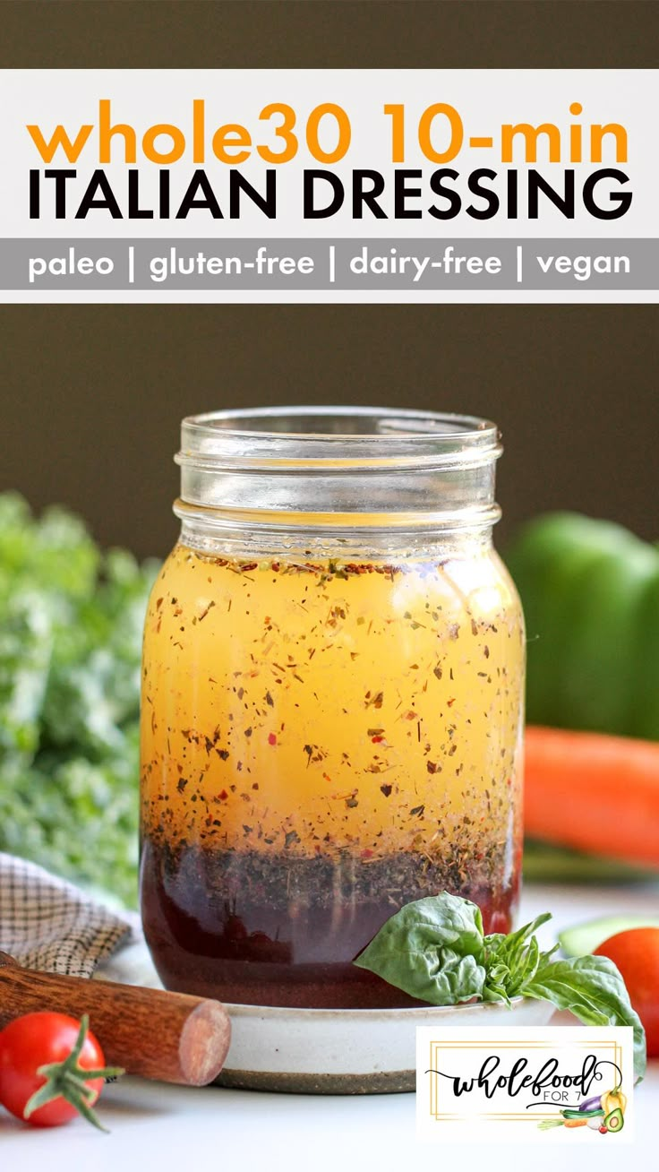 a jar filled with liquid sitting on top of a table next to vegetables and herbs