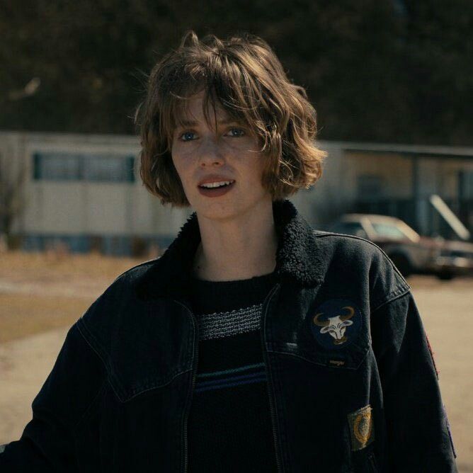 a young man standing in front of a parking lot