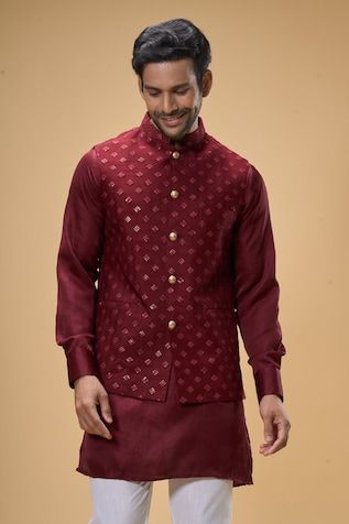 Maroon sleeveless bundi crafted in dupion silk with sequin-thread bloom quad embroidery. Paired with a solid maroon kurta and a white pant. - Aza Fashions Festive Sleeveless Silk Kurta, Elegant Chanderi Nehru Jacket For Festive Occasions, Sleeveless Nehru Jacket With Zari Work For Transitional Season, Fitted Cotton Silk Bandhgala With Cutdana, Designer Chanderi Nehru Jacket Fitted, Fitted Chanderi Nehru Jacket For Designer Wear, Festive Cotton Silk Fitted Nehru Jacket, Festive Sleeveless Nehru Jacket With Resham Embroidery, Elegant Chanderi Nehru Jacket For Diwali