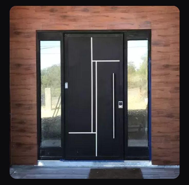 a black door with white lines on the glass and wood paneled wall behind it