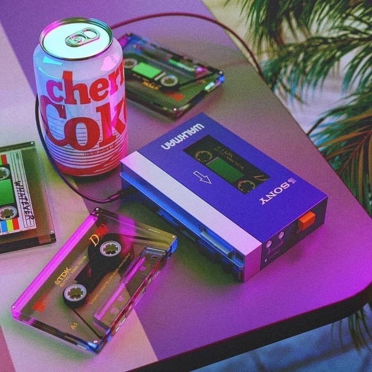 a table topped with different types of games and cassettes next to a can of soda