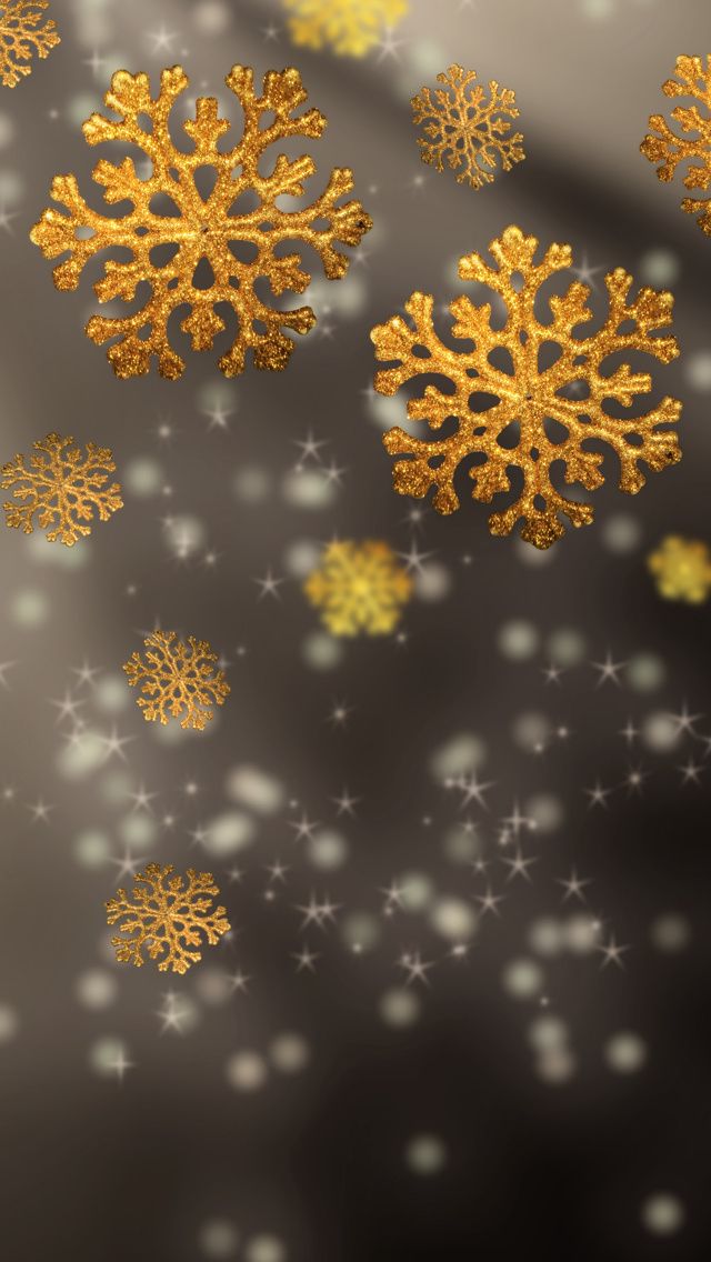 gold snowflakes are flying through the air on a gray and silver background with white stars