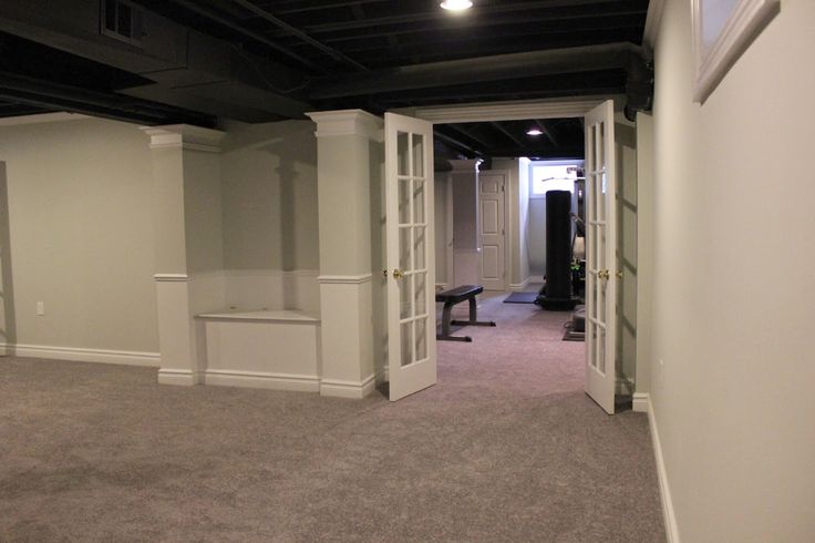 an empty living room with white walls and carpeted flooring is seen in this image