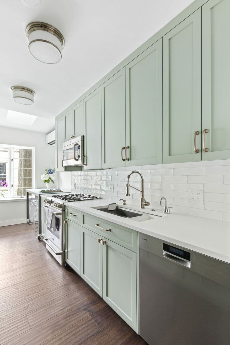 an empty kitchen with green cabinets and white counter tops is pictured in this image from the inside