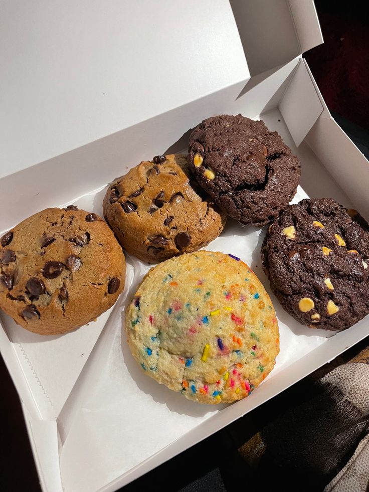 a box filled with assorted cookies and muffins