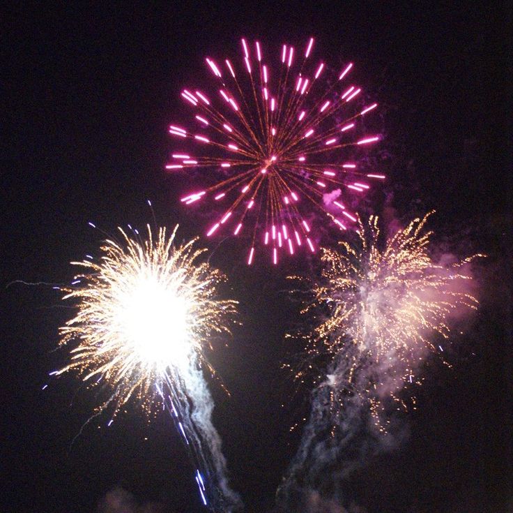 fireworks are lit up in the night sky with pink and purple colors on them,