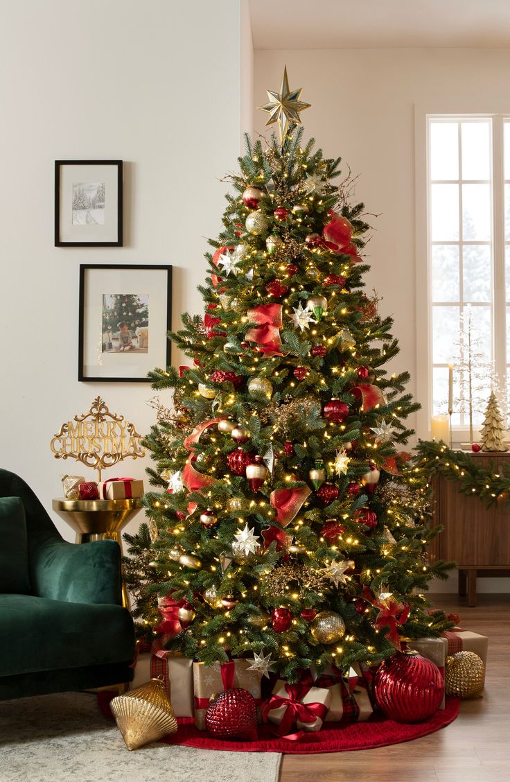 a decorated christmas tree in a living room with red and gold ornaments on the floor