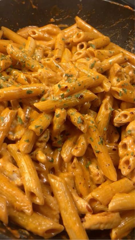 pasta with sauce and parmesan cheese in a frying pan on the stove