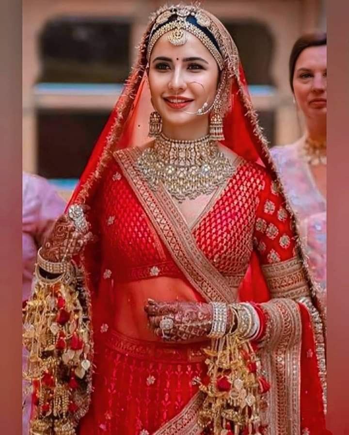 a woman in red and gold bridal outfit