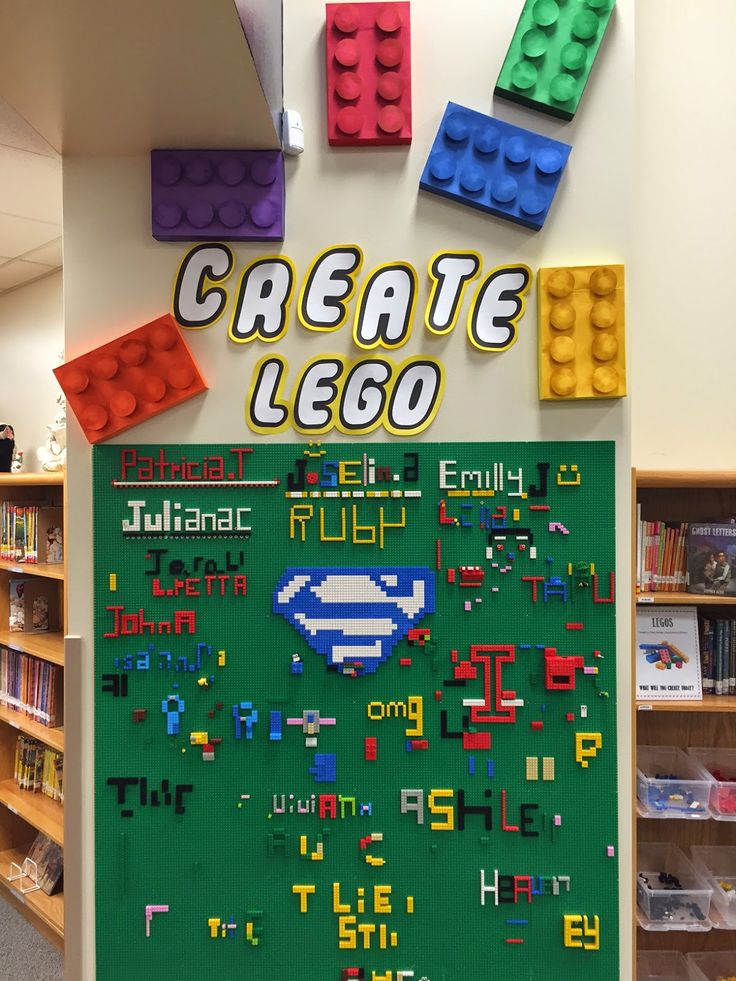 a display in a library with legos on the wall and bookshelves behind it