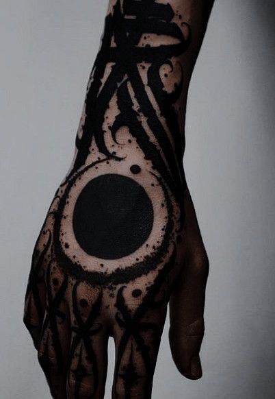 a person's hand with black ink on it and an eye in the middle