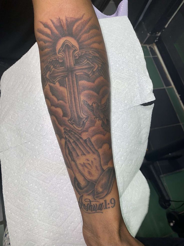 a man with a cross tattoo on his arm