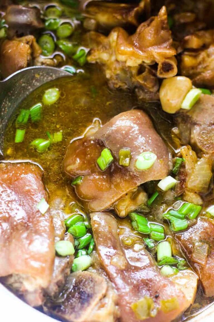 a close up of food in a pot with the words pig feet recipe above it