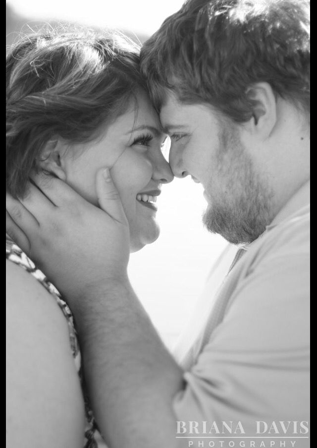 black and white photograph of a man and woman smiling at each other with their faces close together