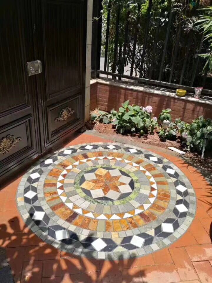 an outdoor area with a circular mosaic design on the ground