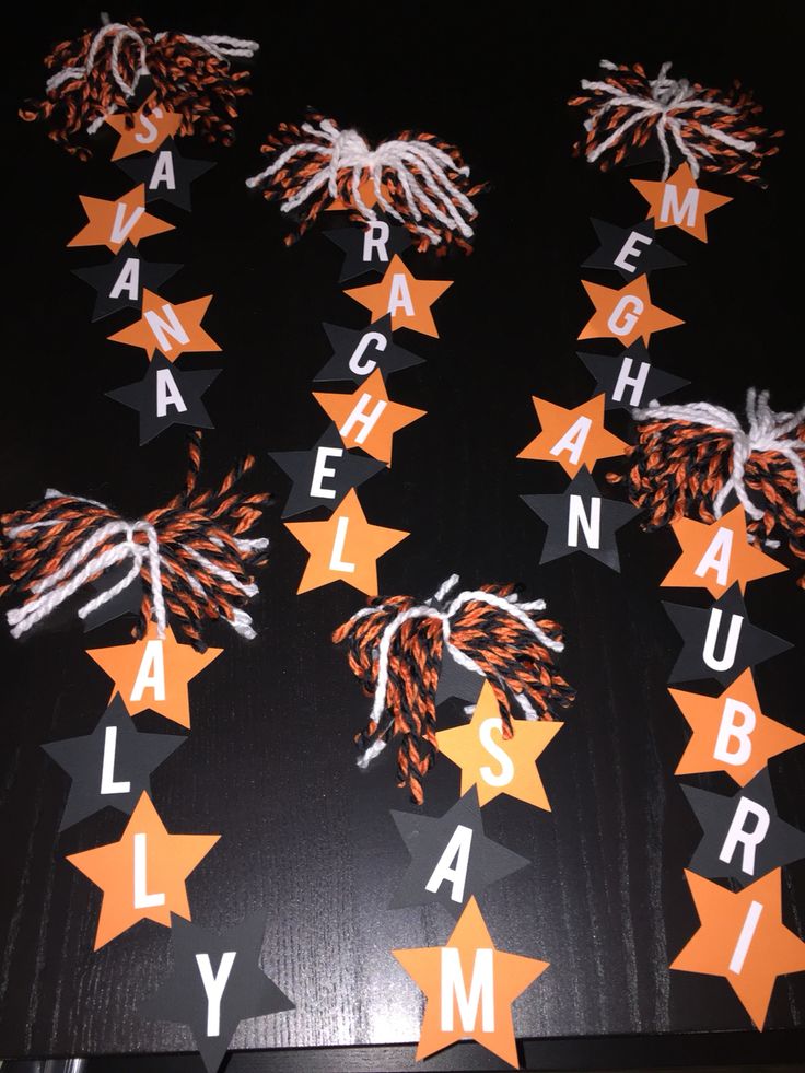 several orange and white stars are arranged in the shape of letters on a black background