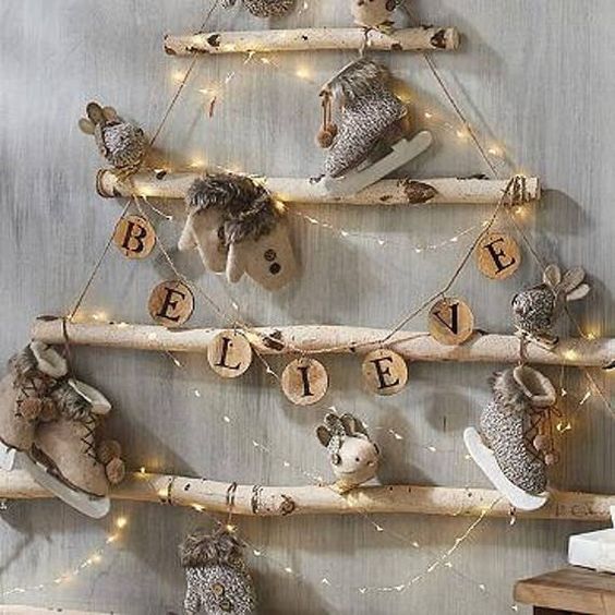 a christmas tree made out of wooden logs with stuffed animals on it and lights strung from the branches