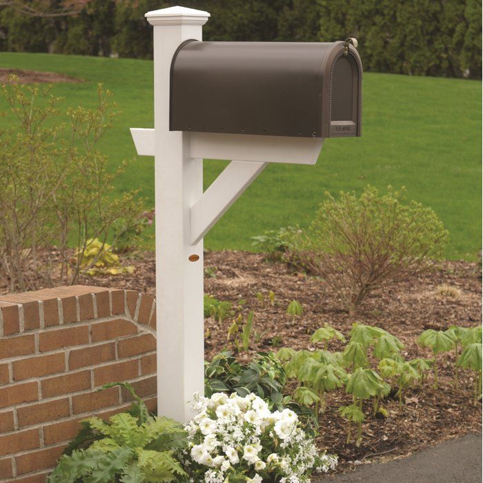 a mailbox in the middle of a flower bed